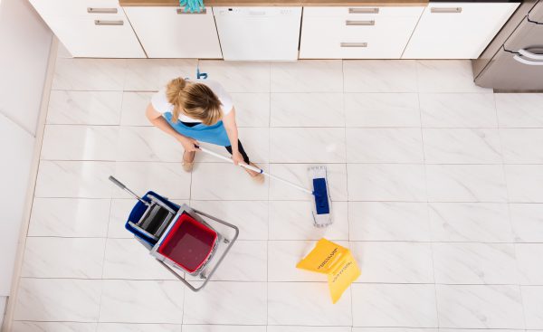 Housemaid Mopping Floor In Kitchen